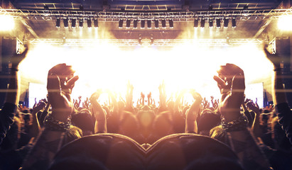 Concert spectators in front of a bright stage with live music