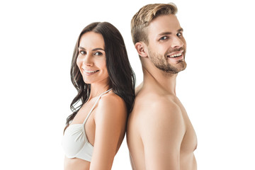 happy young couple standing back to back and looking at camera, isolated on white