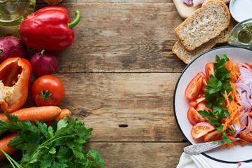 Vegetable salad with tomatoes, bell pepper, carrots, onion and parsley on a plate