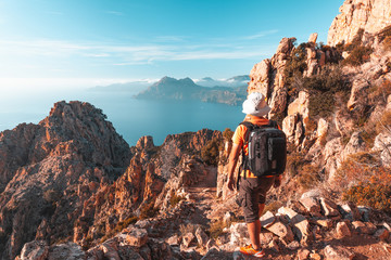 Hiker looking at the view at Calanques de Piana in Corsica, France - obrazy, fototapety, plakaty