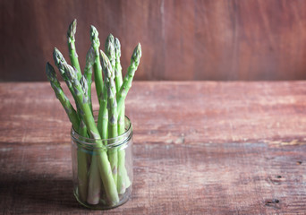 Banches of fresh green asparagus on wooden background