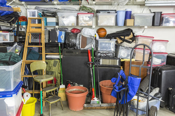 Messy cluttered garage filled with various household storage items.