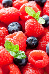 Bunch Of Raspberries And Blueberries With Mint Leaves