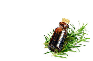 Organic rosemary leaves and essential oil on white background.