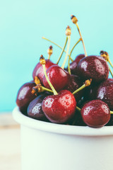 cherries in a white enamel mug on a wooden table, fresh cherry, seasonal berries, sweet cherry, ripe berries, berries in to the handle