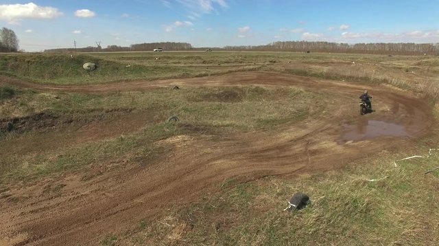 Aerial: Man riding a motor cross bike cross-country. Outdoor motor sport from drone view.