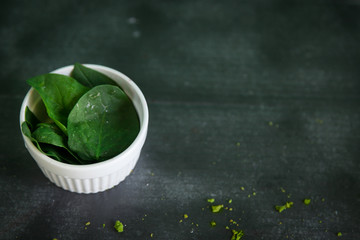 Fresh spinach leaves in a white bowl
