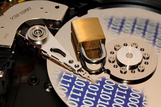 concept of data protection. open hard disk drive with binary code effect and closed padlock over.