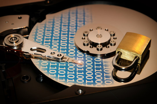 concept of data protection. open hard disk drive with binary code effect and closed padlock over.