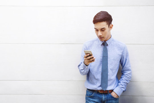 Portrait of Young Smart Businessman using Smartphone at Building Wall, Lifestyle of Modern Male