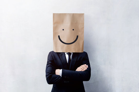 Customer Experience Concept, Portrait of Happy Businessman Client with Smiley Face Emotion on Paper Bag, Crossed arms and wearing Suit, Standing at the Concrete Wall