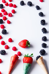 Frame isolated of Composition of fresh summer fruit, raspberries, blackberries, Strawberry and Cones on white background. Mediterranean diet with varied summer fruits. Stock photo. Top View