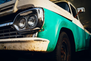 Front end of a vintage truck in the headlights.
