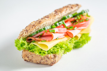 Tasty roll with cheese, ham and cucumber for breakfast