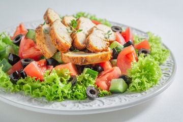 Fresh Caesar salad with tomatoes, cucumber and chicken