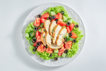 Fresh Caesar salad with chicken, olives and tomatoes