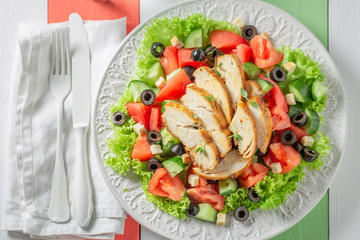 Delicious Caesar salad with chicken, olives and tomatoes