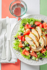 Tasty Caesar salad with olives, tomatoes and lettuce