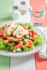 Delicious Caesar salad with tomatoes, cucumber and chicken