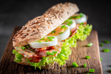 Delicious sandwich with lettuce, bacon and eggs