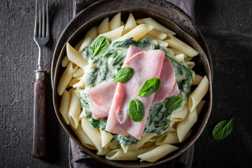 Hot penne with bechamel sauce, ham and spinach
