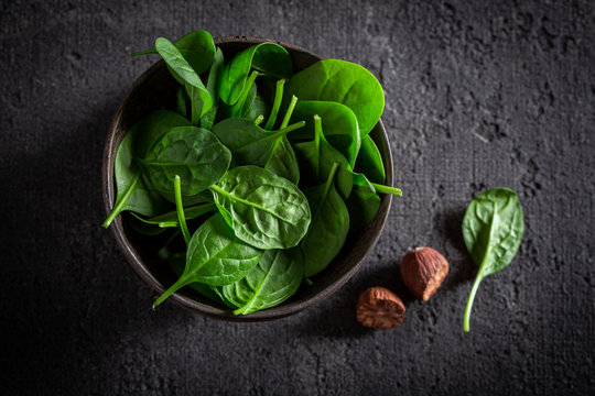 Fresh green spinach on gray old stone