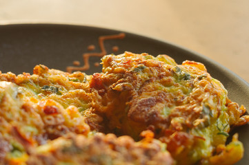 Fried vegetable fritters with zucchini, carrots, herbs, eggs, and cheese.