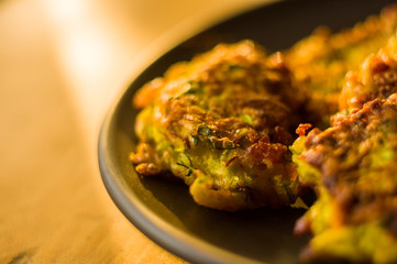 Fried vegetable fritters with zucchini, carrots, herbs, eggs, and cheese.