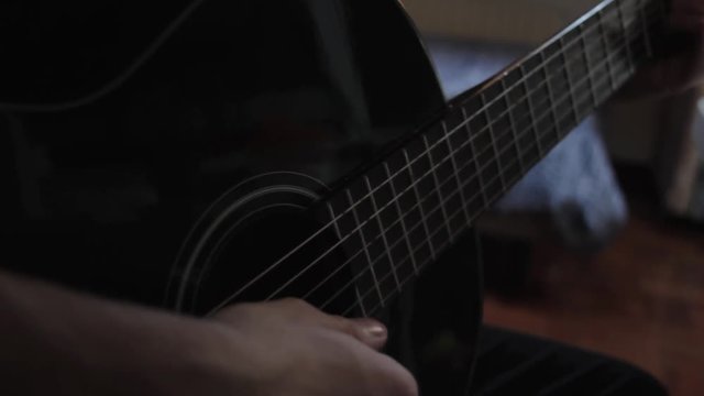 Detalle de un joven tocando la guitarra