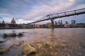 St. Paul's Cathedral and the Millenium Bridge seen from the river bank with the Thames at low tide