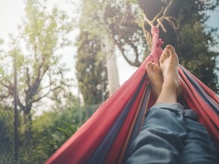 nude feet relaxing on hammock in spring season
