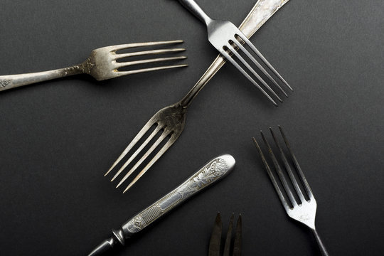 Vintage metallic cutlery and kitchen utensils on gray background
