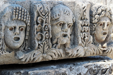 Theatrical masks adorn the stone blocks in front of the facade of the theater. The ancient Greco-Roman theatre in Myra (Demre — Turkey)
