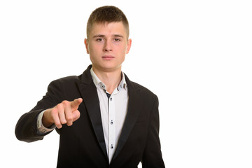 Studio shot of young businessman pointing finger at camera