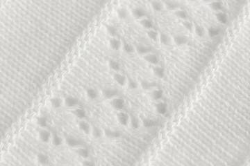 Knitted fabric with an openwork pattern, handmade. Background, texture