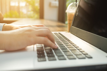 Close-up of Business female working with laptop coffee and smart phone in coffee shop like the background.