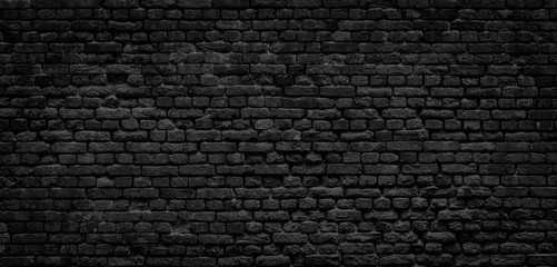 Old black brick wall panorama background.
