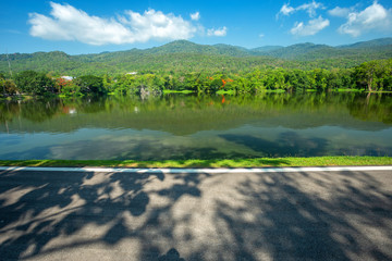 Along road landscape view in Ang Kaew Chiang Mai University Forested Mountain blue sky background with white clouds, Nature Road in mountain forest.