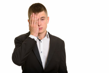 Studio shot of young businessman looking tired