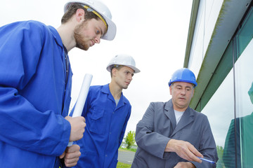 apprentices and teacher near building