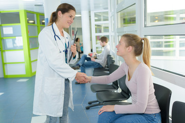 female doctor shaking hands with patient