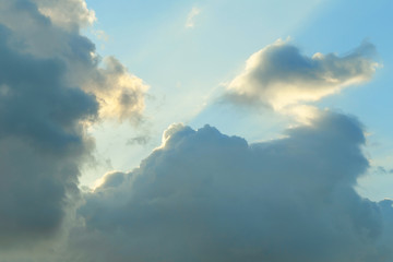 Fototapeta na wymiar Sunbeams in the clouds at sunset, blue sky background