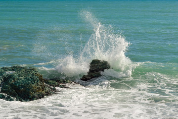 Big waves breaking on the shore with sea foam