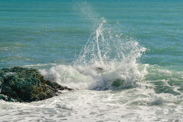 Big waves breaking on the shore with sea foam