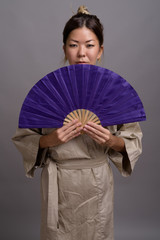 Obraz premium Young beautiful Kazakh woman against gray background