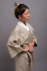 Young beautiful Kazakh woman against gray background