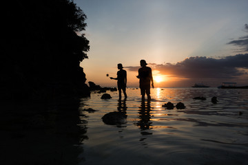 2 Boys Fishing For Sea Urchins on a Sunset Coast