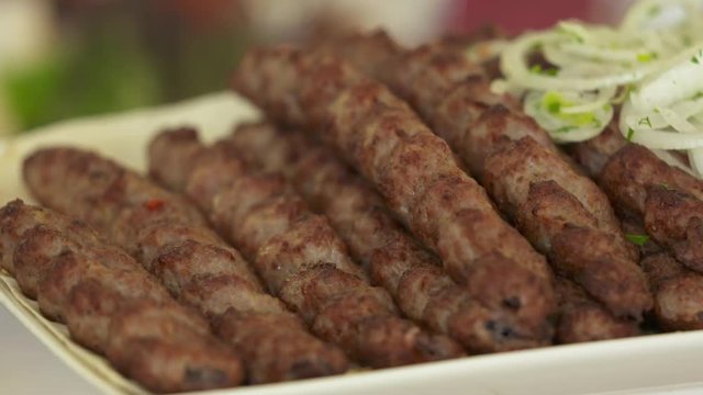 Dinner table served with lula kebabs and fresh vegetables. Armenian style kebab.