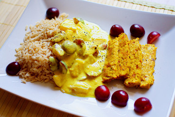 Colorful vegan curry with fruit, rice and tofu