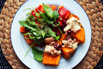 Delicious sweet potato dish with hummus, beans and salad